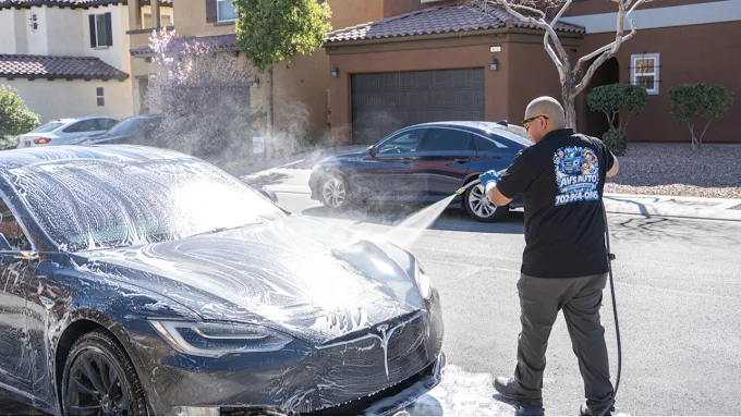AV's Auto Detail hand-washing a black Tesla with foam in a Las Vegas driveway