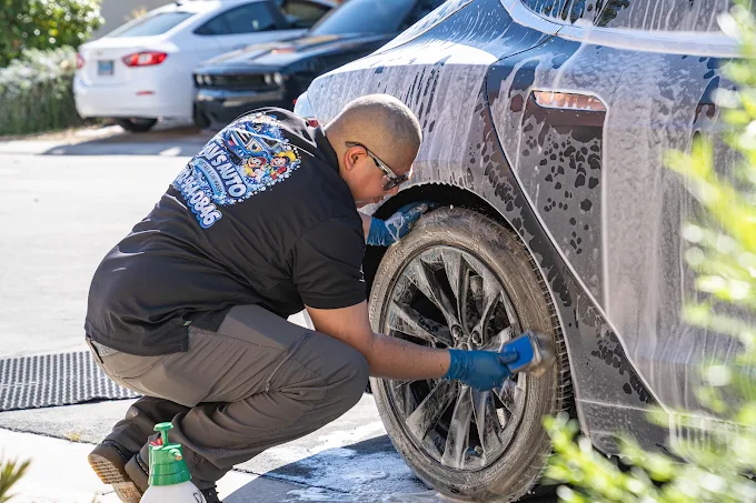 AV's Auto Detail owner hand-scrubbing a wheel and tire during a mobile detail in Las Vegas